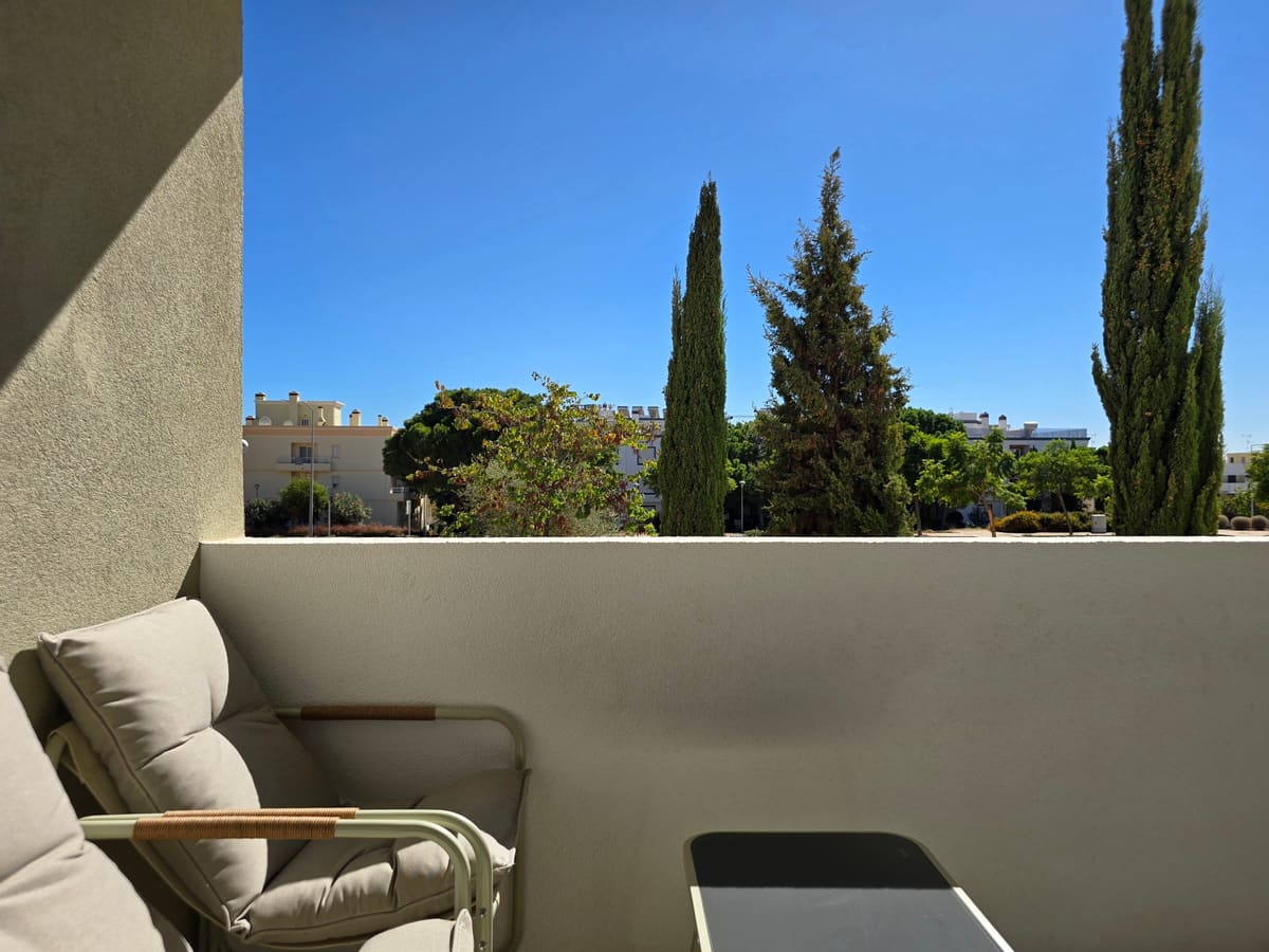 South facing balcony with two chairs, looking over cypress and pine trees