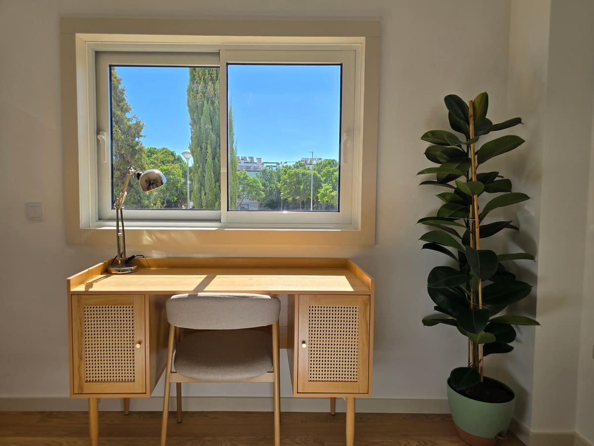Wooden desk and chair under the window of the second bedroom