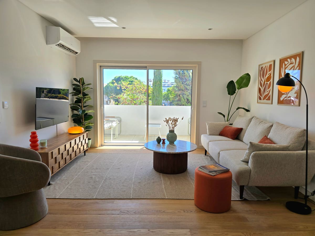 Living room with a sofa, a round marble table and sliding doors to the balcony