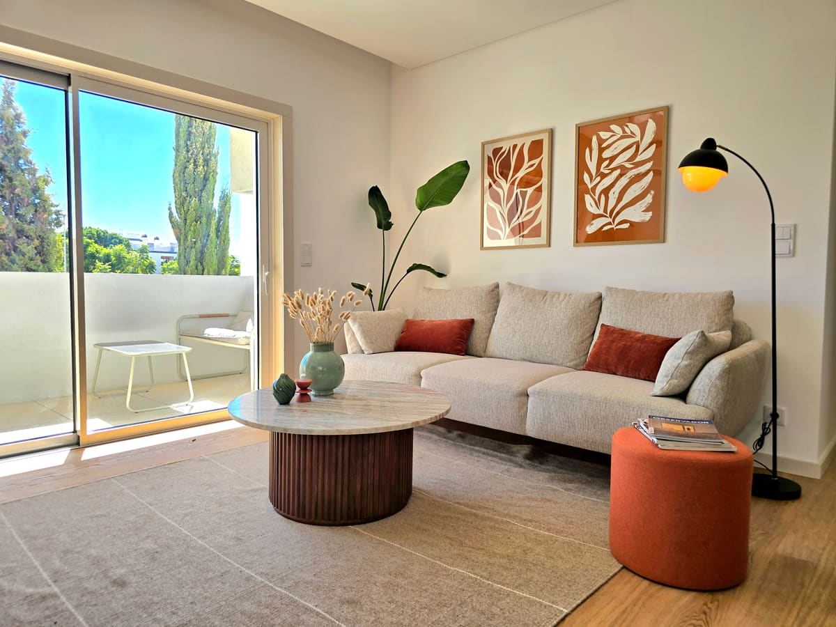 Sofa, round table and armchair in front of the balcony doors
