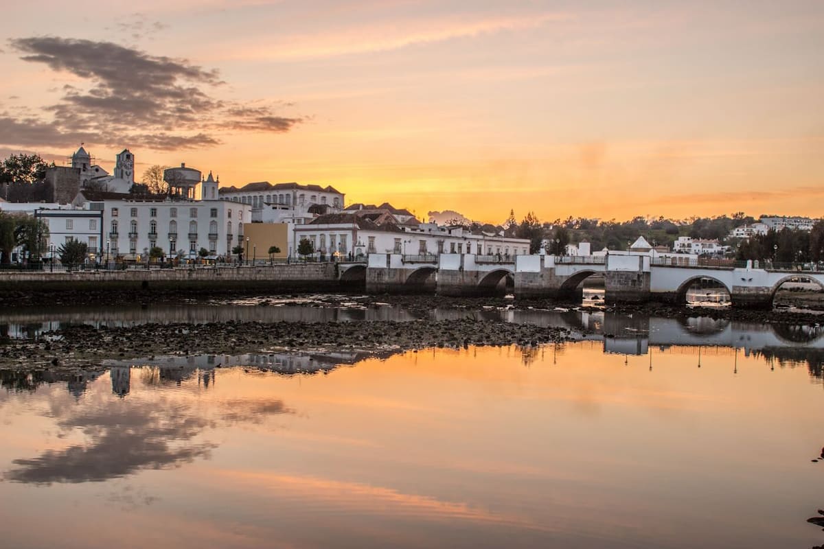 Tavira’s old bridge over the Gilão river at sunset, with the town behind